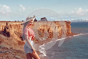 Happy pinup girl outdoor portrait. Travel vacation fun summer woman with hat enjoying freedom over Black sea. Carefree girl