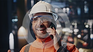 Happy plant worker calling at industrial facility feeling success close up.