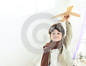Happy play boy with airplane in hand indoors