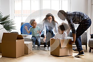 Happy playful African American family moving in new apartment