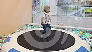 Happy playful little boy 2-3 years old jumping on a trampoline in shopping mall