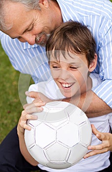 Happy, playing and a father with a child for soccer, game and a competition in the backyard. Smile, laughing and a dad