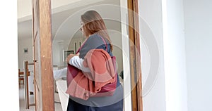 Happy plus size biracial female doctor arriving home from work, opening front door, slow motion