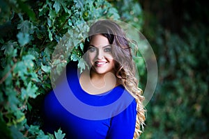 Happy plus size fashion model in blue dress outdoors, fat woman with beauty makeup and hairstyle