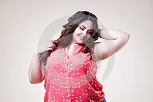 Happy plus size fashion model in casual clothes, cheerful fat woman on beige background
