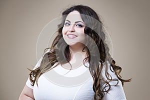 Happy plus size fashion model in casual clothes, fat woman on beige background, overweight female body