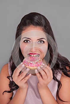 Happy plus size woman with donut. Body positive concept