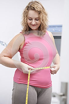 Happy Plus Size Woman Measuring Waist In Bathroom