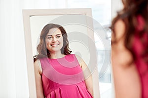 Happy plus size woman posing at home mirror