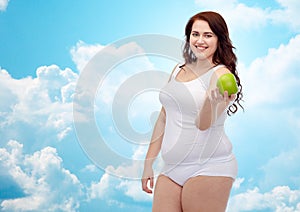 Happy plus size woman in underwear with apple