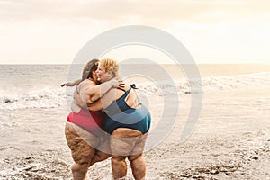 Happy plus size women having fun on sunny day at beach during vacation