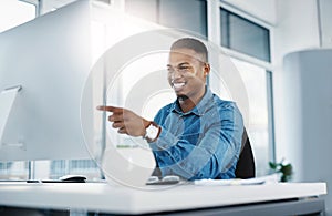 Happy, pointing and black man by computer in office, workspace and desk confident in creative career. professional