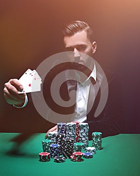 Happy poker player winning and holding a pair of aces