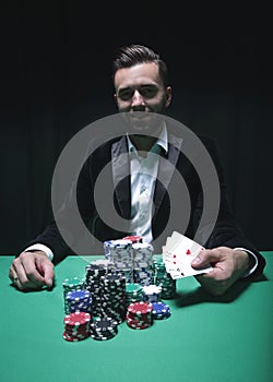 Happy poker player winning and holding a pair of aces