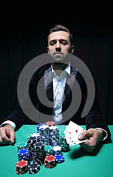 Happy poker player winning and holding a pair of aces