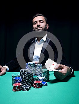 Happy poker player winning and holding a pair of aces