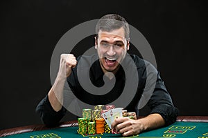 Happy poker player winning and holding a pair of aces