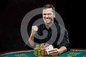 Happy poker player winning and holding a pair of aces