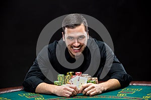 Happy poker player winning and holding a pair of aces