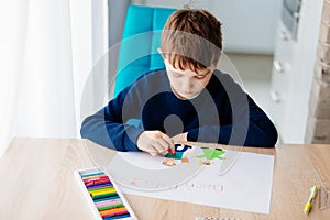 Happy Polish child drawing a greeting card for his grandma.