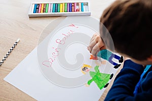 Happy Polish child drawing a greeting card for his grandma.