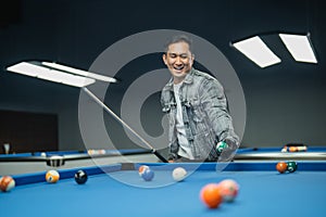 happy pool player smiling while grabbing the billiard ball
