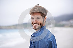 Happy, portrait and beach with man on summer vacation, getaway trip and adventure. Ocean, smile and male person for