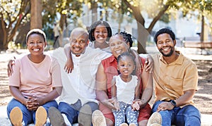 Happy portrait of a black family in nature with mother, grandparents and children smiling next to father. Mom, dad and