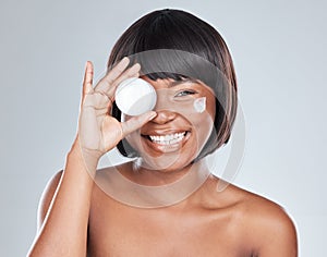 Happy, portrait and black woman with container of cream for skincare or moisturizer on a white studio background. Face