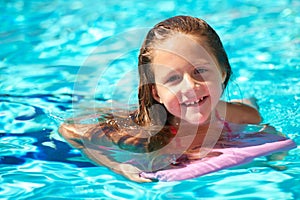 Happy, portrait and child with inflatable in swimming pool, games or learning with support in water park on vacation