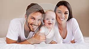 Happy portrait, dad and mom of baby kid on bed for love, care and quality time together to relax at home. Smile of