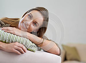 Happy, portrait and girl on sofa to relax for comfort or rest on Saturday afternoon, peace and unwind. Female person