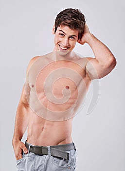 Happy, portrait and handsome man with muscular body in fitness, health or wellness on a gray studio background