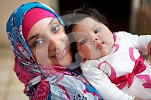 Happy, portrait and muslim mom with baby in home with love and care for family in Saudi Arabia. Infant, child and Arabic