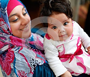 Happy, portrait and muslim mom with baby in home with love and care for family in Saudi Arabia. Infant, child and Arabic