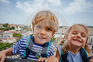 Happy portrait of two kids travelers at Lisbon viewpoint