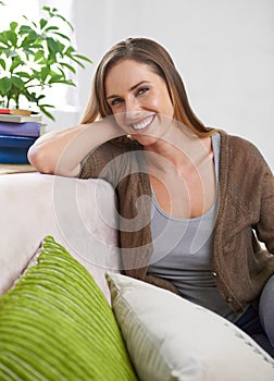 Happy, portrait and woman on sofa to relax for comfort or rest on Saturday afternoon, peace and unwind. Female person