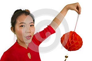 Happy portrait of young beautiful and sweet Asian Chinese woman in traditional bun hair style and red dress holding lantern