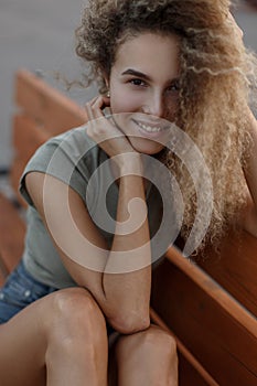 Happy portrait of a young funny curly girl outdoors