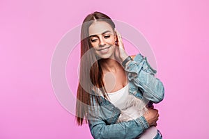 Happy portrait young woman fashion model with sweet smile in stylish blue denim clothes near pink vintage wall. Cheerful