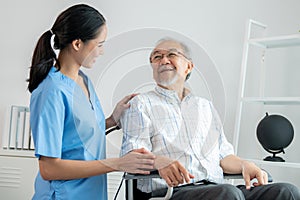 Happy positive asian nurse giving support and touching contented senior man.