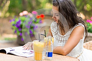 Happy, positive, beautiful, elegance girl sitting at cafe table outdoors.