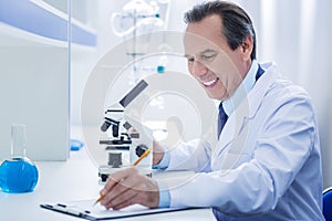 Happy positive biologist writing down his observations