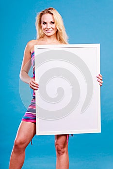 Happy positive blonde woman holding blank white board