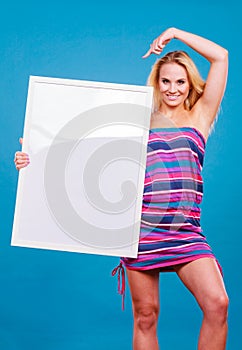 Happy positive blonde woman holding blank white board