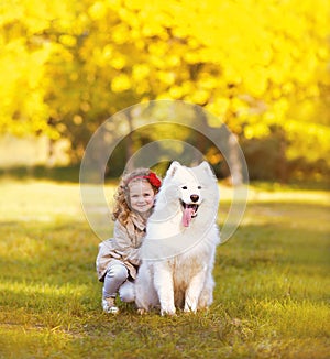 Happy positive child and dog having fun outdoors