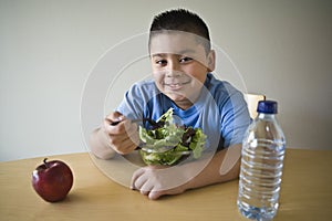 Happy Preadolescent Boy Eating Salad photo