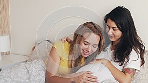 Happy pregnant asian korean woman with friend talking and laughing while celebrating baby shower at home bedroom. Family