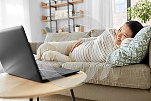 happy pregnant asian woman with laptop at home