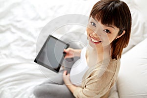 Happy pregnant asian woman with tablet pc at home